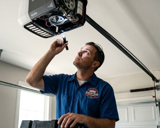 Professional technician performing a garage door opener repair service on a residential motor in Atlanta GA.